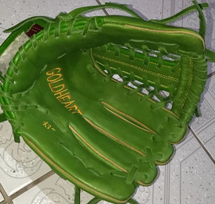 Adjustable wrist strap on RISE fastpitch glove ensuring secure fit for female athletes.